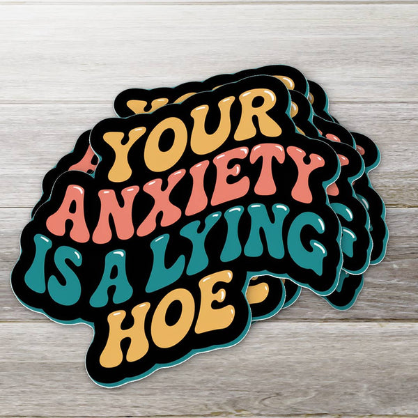 Stack of colorful stickers with text on a wooden surface sticker says your anxiety is a lying ho 