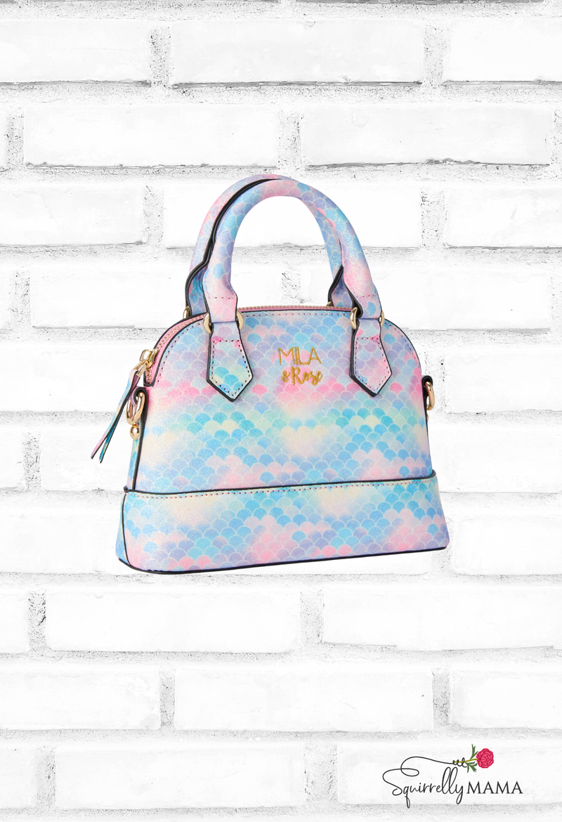 Multicolored patterned handbag with 'Mila' branding on a white brick background