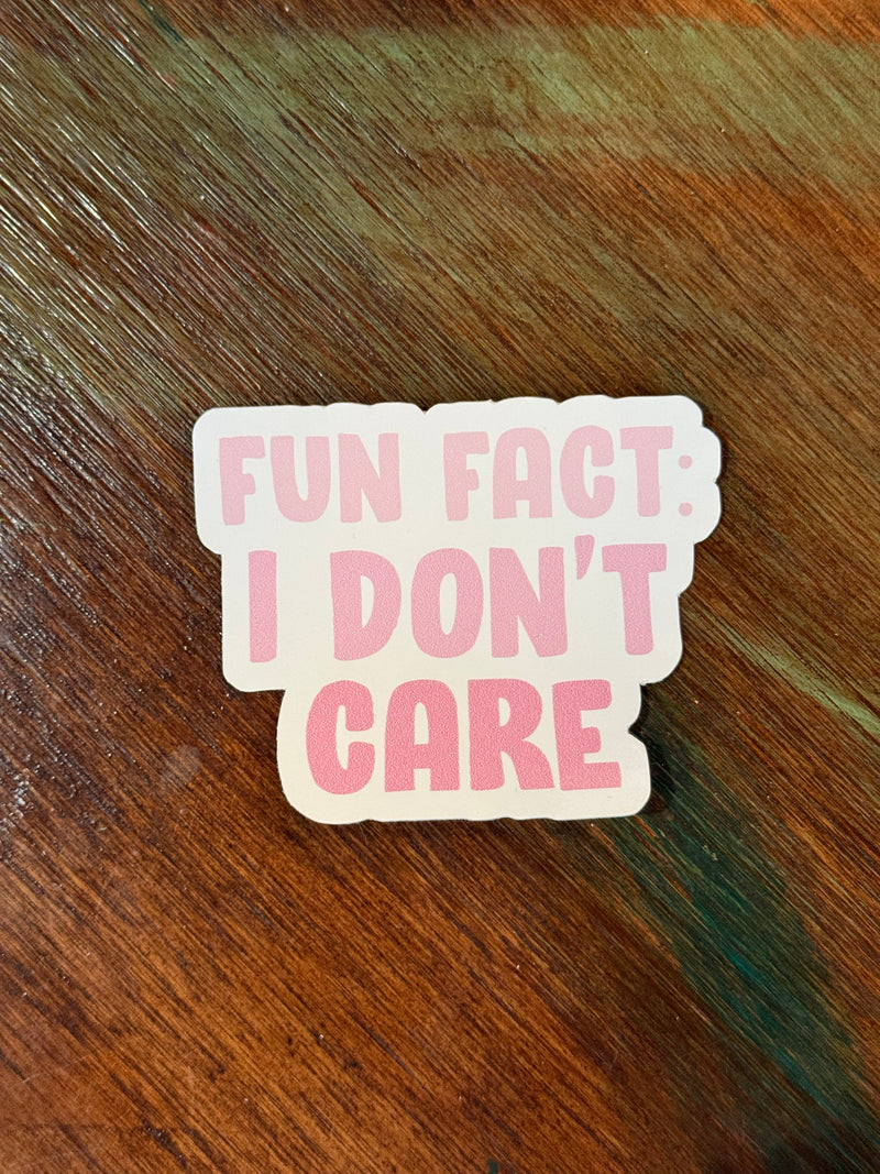 Sticker with 'FUN FACT: I DON'T CARE' text on a wooden surface