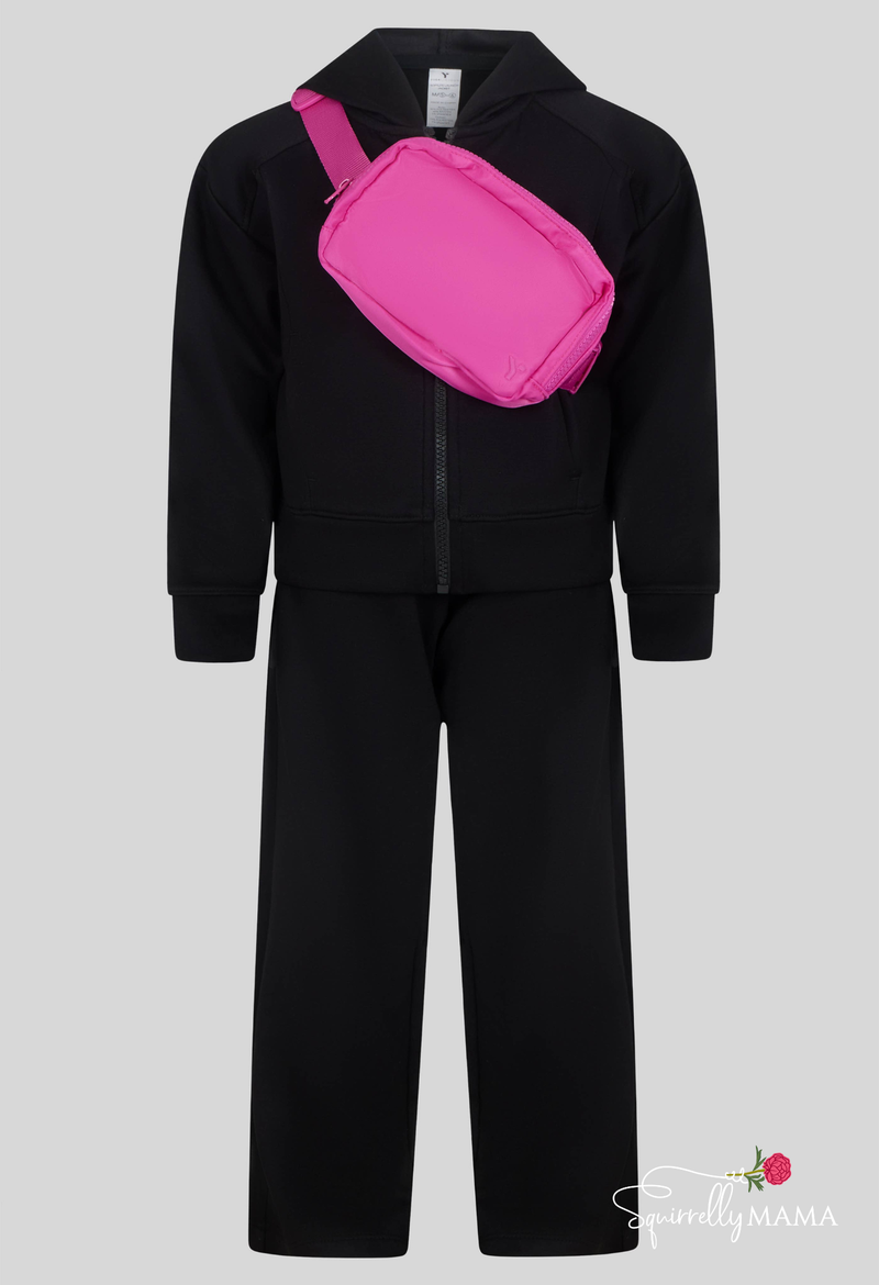 little girls black tracksuit with a pink bag on a gray background