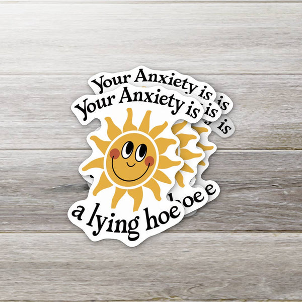 Sticker with a sun graphic and text on a wooden surface