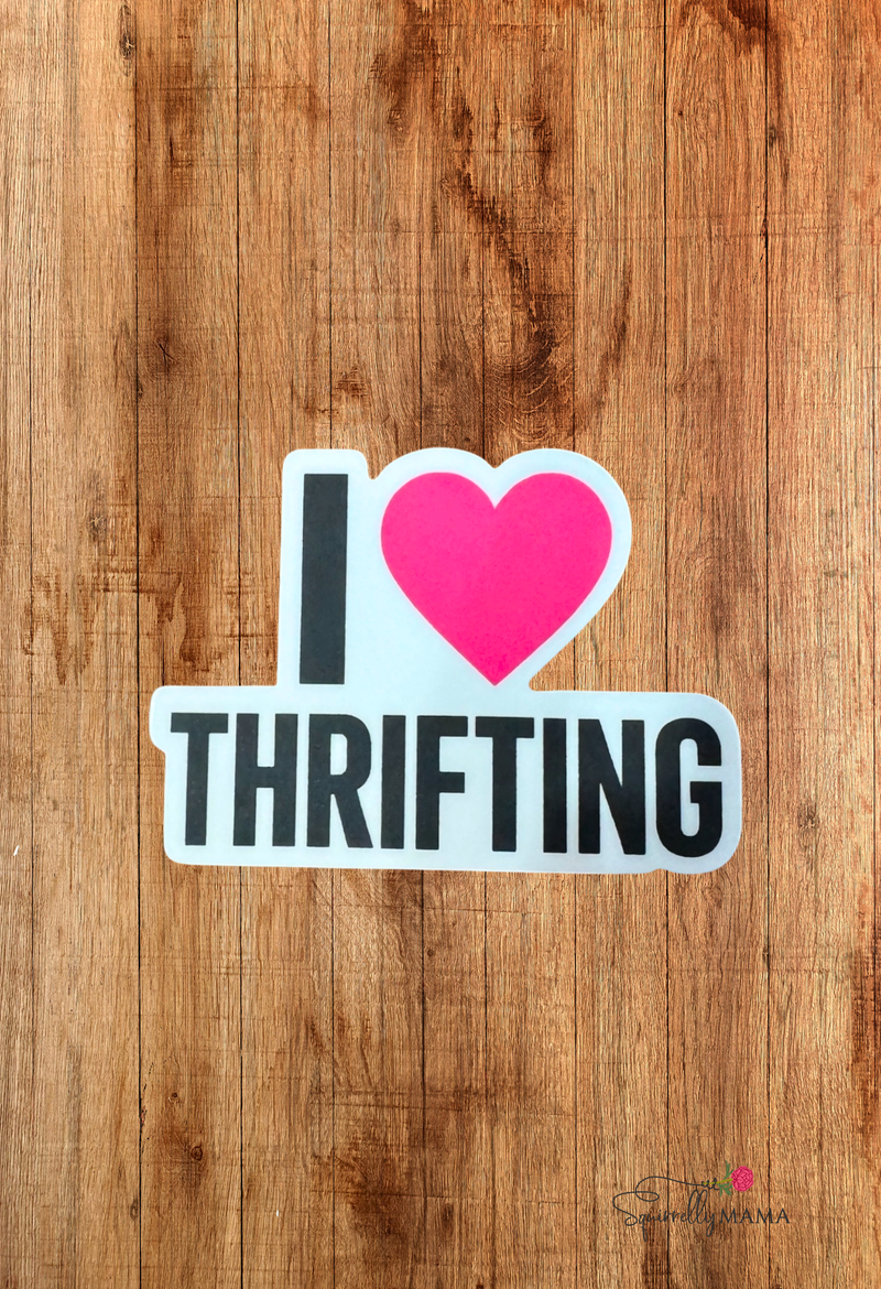 Sticker with 'I ❤️ Thrifting' text on a wooden background