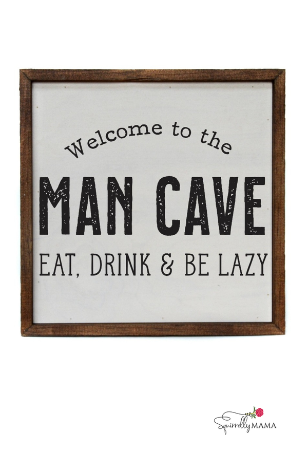 Wooden sign that says ‘Welcome to the Man Cave – Eat, Drink & Be Lazy’ with rustic brown frame.
