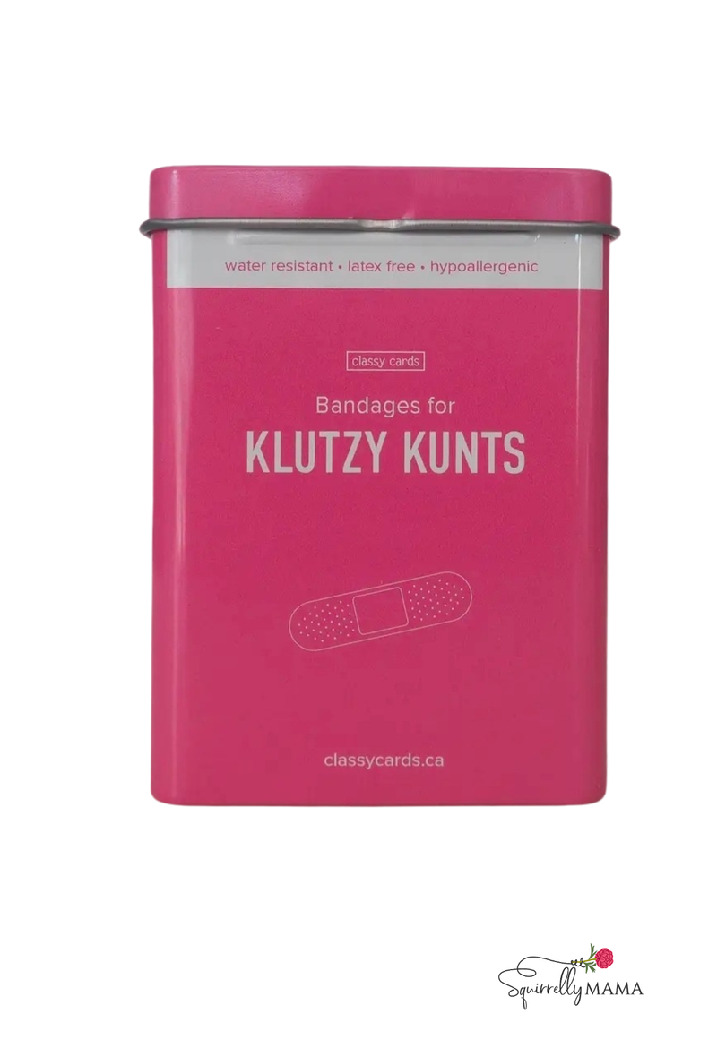 Bright pink tin labeled “Bandages for Klutzy Kunts” by Classy Cards, featuring a simple bandage illustration on the front.