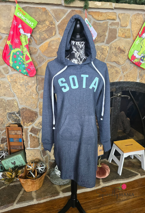 Blue hoodie dress with 'SOTA' text on a stand against a stone wall background